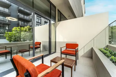 a balcony of a building with chairs and windows at HAVN - Brand New Studio in Oxford Boulevard, JVC in Dubai