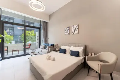 a bedroom with a bed and a chair and a couch at HAVN - Brand New Studio in Oxford Boulevard, JVC in Dubai