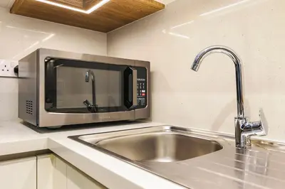 a kitchen with a stainless steel sink and a microwave at FIRST CLASS 1BR Modern Comfort in the City in Dubai