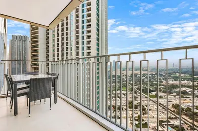 a balcony with a table and chairs and a view of the city at FIRST CLASS 1BR Modern Comfort in the City in Dubai