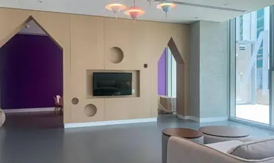 a living room with a couch and a tv on a wall at Luxury Skyline View 1BR with Pool, Gym, Parking, Concierge & Near Metro in Dubai
