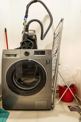 a washing machine with a vacuum on top of it at Luxury Skyline View 1BR with Pool, Gym, Parking, Concierge & Near Metro in Dubai