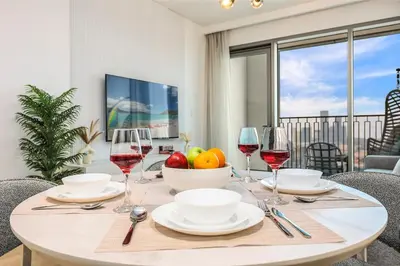 a table with wine glasses and a bowl of fruit at Luxury Skyline View 1BR with Pool, Gym, Parking, Concierge & Near Metro in Dubai