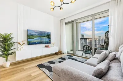a living room with a couch and a large window at Luxury Skyline View 1BR with Pool, Gym, Parking, Concierge & Near Metro in Dubai