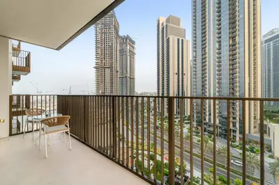 a balcony with a table and a view of the city at Prime 2BR Retreat, Creek Harbour Views & Comfort Near Restaurants in Dubai