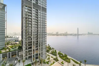 a rendering of a tall building next to a body of water at Prime 2BR Retreat, Creek Harbour Views & Comfort Near Restaurants in Dubai