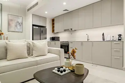 a living room with a white couch and a table at Prime 2BR Retreat, Creek Harbour Views & Comfort Near Restaurants in Dubai