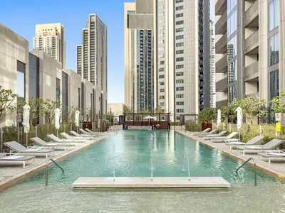 a large swimming pool in a city with tall buildings at Luxury 2BR Dubai Creek Harbour with Pool, Gym, Parking & Balcony Views in Dubai