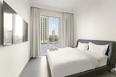 a bedroom with a white bed and a large window at Luxury 2BR Dubai Creek Harbour with Pool, Gym, Parking & Balcony Views in Dubai
