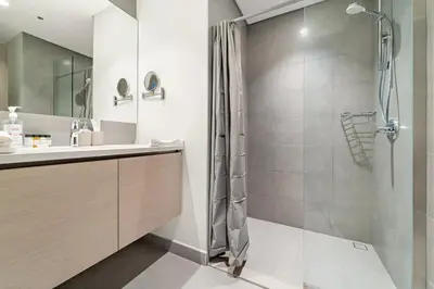 a bathroom with a shower and a sink at Luxury 2BR Dubai Creek Harbour with Pool, Gym, Parking & Balcony Views in Dubai