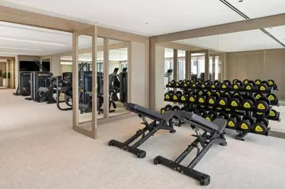 a gym with a row of treadmills and exercise bikes at Luxury 2BR Dubai Creek Harbour with Pool, Gym, Parking & Balcony Views in Dubai