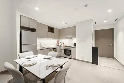 a kitchen and dining room with a table and chairs at Luxury 2BR Dubai Creek Harbour with Pool, Gym, Parking & Balcony Views in Dubai