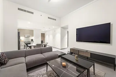 a living room with a couch and a flat screen tv at Luxury 2BR Dubai Creek Harbour with Pool, Gym, Parking & Balcony Views in Dubai