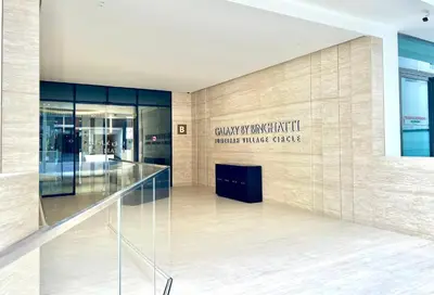 a lobby of a building with a sign on the wall at Lush Studio in Binghatti Galaxy in Dubai