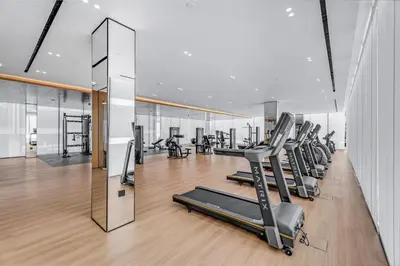 a gym with a row of treadmills and ellipticals at Lush Studio in Binghatti Galaxy in Dubai