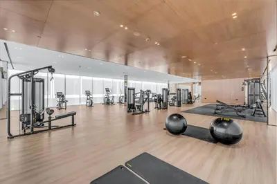 a gym with several treadmills and exercise machines at Lush Studio in Binghatti Galaxy in Dubai
