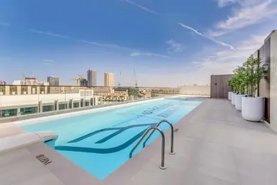 a swimming pool on the roof of a building at Lush Studio in Binghatti Galaxy in Dubai