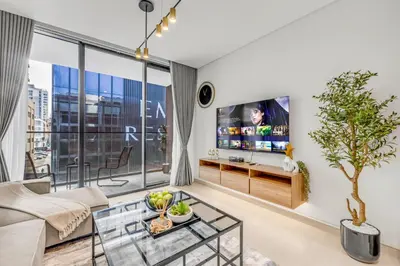 a living room with a couch and a tv at Lush Studio in Binghatti Galaxy in Dubai