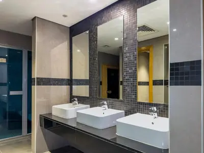 two sinks in a bathroom with two mirrors at Dubai 1BR Balcony Views Near Miracle Garden in Dubai