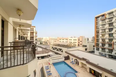 a view from the balcony of a building with a swimming pool at Dubai 1BR Balcony Views Near Miracle Garden in Dubai