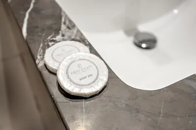 two complimentary toiletries are sitting next to a sink at FIRST CLASS 1BR Living Garden Luxury and Comfort in Dubai