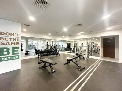 a gym with a lot of equipment in a room at FIRST CLASS 1BR Living Garden Luxury and Comfort in Dubai