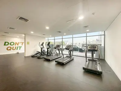a gym with treadmills and a row of treadleys at FIRST CLASS 1BR Living Garden Luxury and Comfort in Dubai
