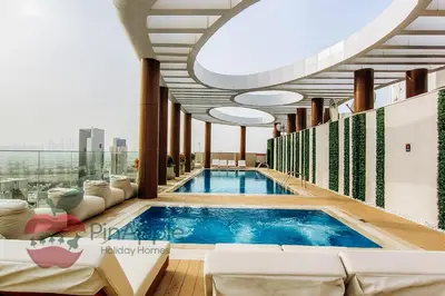 a large swimming pool in a building with a large ceiling at Beautiful Brand New Studio in Dubai