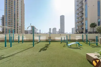 an empty playground in a city with tall buildings at Vogue JVC Jeewar Tower near Circle Mall, One Bedroom Apartment with Balcony and City View, Access to all Amenities in Dubai
