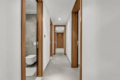 a corridor of a bathroom with a toilet and a mirror at Brand New Luxury 2 Bedroom in Dubai