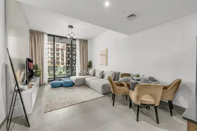 a living room with a couch and a table and chairs at Brand New Luxury 2 Bedroom in Dubai