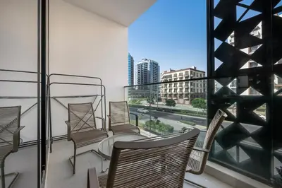 a balcony with chairs and a view of a city at Brand New Luxury 2 Bedroom in Dubai