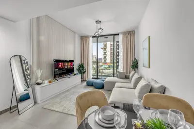 a living room with a couch and a table and a tv at Brand New Luxury 2 Bedroom in Dubai