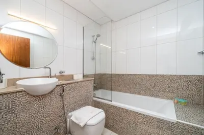 a bathroom with a toilet and a sink and a tub at Modern Studio in the Heart of Sports City in Dubai