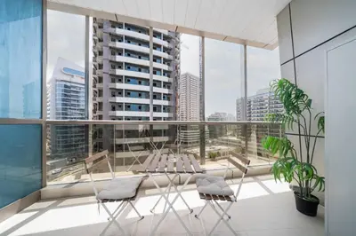 a balcony with chairs and a view of a city at Modern Studio in the Heart of Sports City in Dubai
