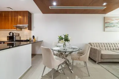 a kitchen and dining room with a glass table and chairs at Modern Studio in the Heart of Sports City in Dubai