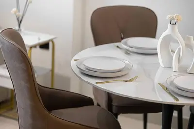 a white table with chairs and plates on it at Luxury Stay in JVC in Dubai