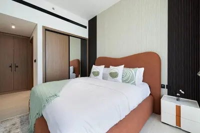 a bedroom with a large bed with white sheets at Luxury Stay in JVC in Dubai