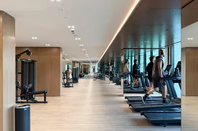 a gym with people exercising on treadles in a building at Luxury Stay in JVC in Dubai