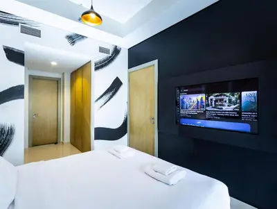 a bedroom with a white bed and a flat screen tv at Modern 2BR Apartment with Stunning City Views in Dubai