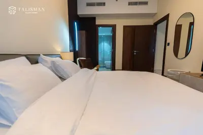 a large white bed in a hotel room at Elegant 1 BR Apartment in J One Tower in Dubai
