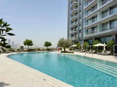 a swimming pool in front of a building at Vida Dubai Mall Connected 2BR in Sabkhah