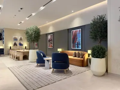 a waiting room with couches and tables and plants at Vida Dubai Mall Connected 2BR in Sabkhah