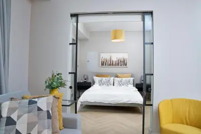 a bedroom with a bed and a yellow chair at Vista Downtown Poolside 1BR Walk to Burj Khalifa in Dubai