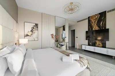 a white bedroom with a large bed and a flat screen tv at FIRST CLASS Villa Private Pool & Garden Bliss in Dubai