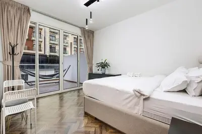 a white bedroom with a bed and a balcony at FIRST CLASS VILLA Tranquility Meets Luxury in Dubai
