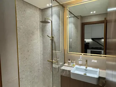 a bathroom with a sink and a shower with a mirror at DVR Studio Apartment with private jaccuzi in Trillionaire by Binghatti Business Bay in Dubai