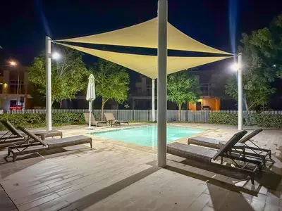 a large yellow umbrella over a swimming pool at night at FIRST CLASS VILLA Spacious for Family Getaways in Dubai