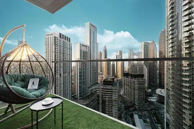 a chair on a balcony with a view of a city at Restay Homes at Act Towers by Emaar - Pool access with Burj View included - Luxury Apartments in Downtown in Dubai