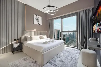 a bedroom with a large bed and a large window at Restay Homes at Act Towers by Emaar - Pool access with Burj View included - Luxury Apartments in Downtown in Dubai